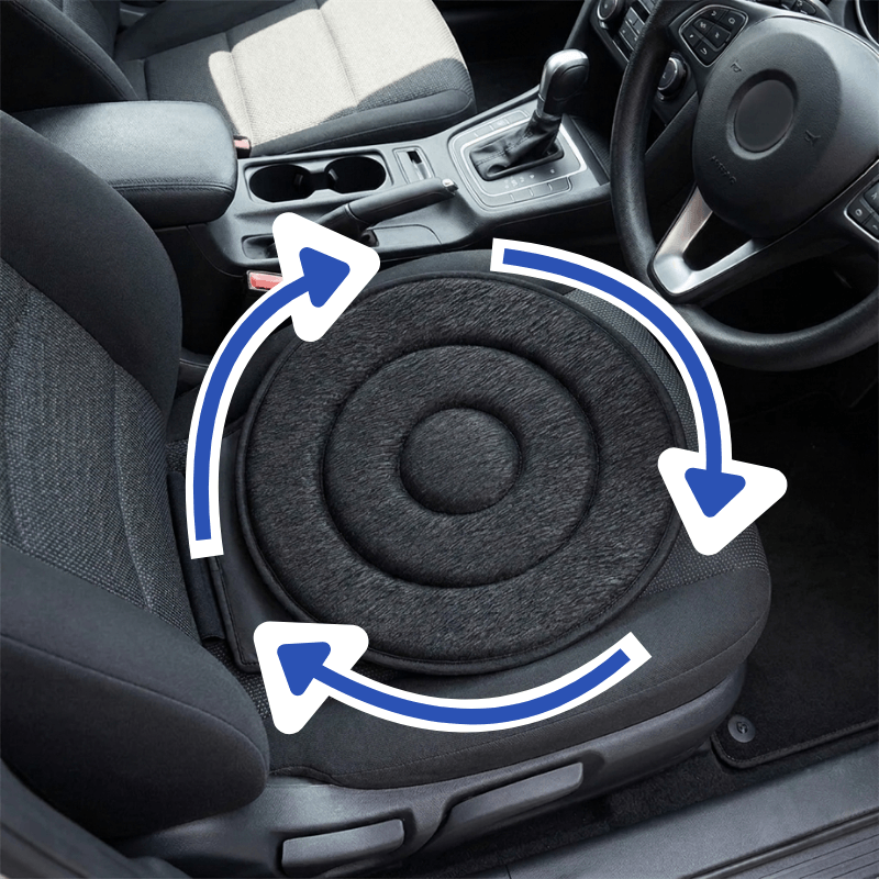 A circular black car seat cushion placed on a front passenger seat inside a vehicle, with blue arrows overlaid to suggest rotation or support. The image shows the car interior, including the steering wheel, gear shift, and adjacent seat.